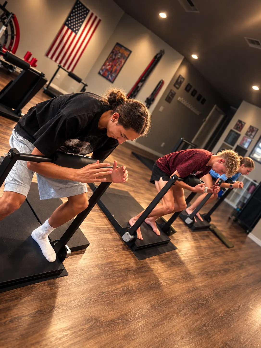 Three Alpha Shield student athletes completing an isometric training session at Sweat Is Free